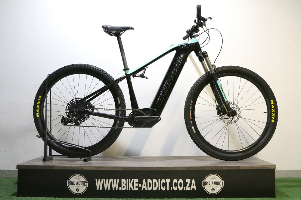 Black electric bike on a stand with a white background
