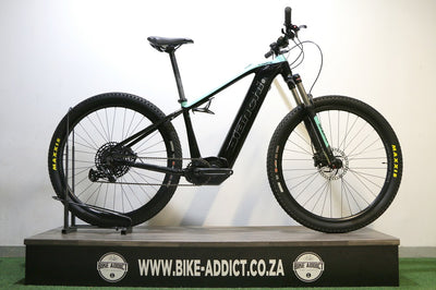 Black electric bike on a stand with a white background